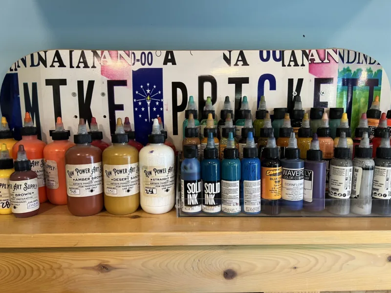 Closeup of a row of tattoo ink bottles on a shelf